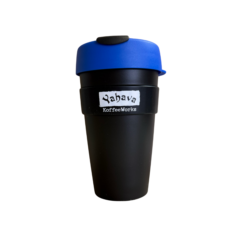 A reusable coffee travel mug with a matte black body, a bright blue lid, and a black silicone flip-top spout. A white label on the front reads 'Yahava KoffeeWorks'.
