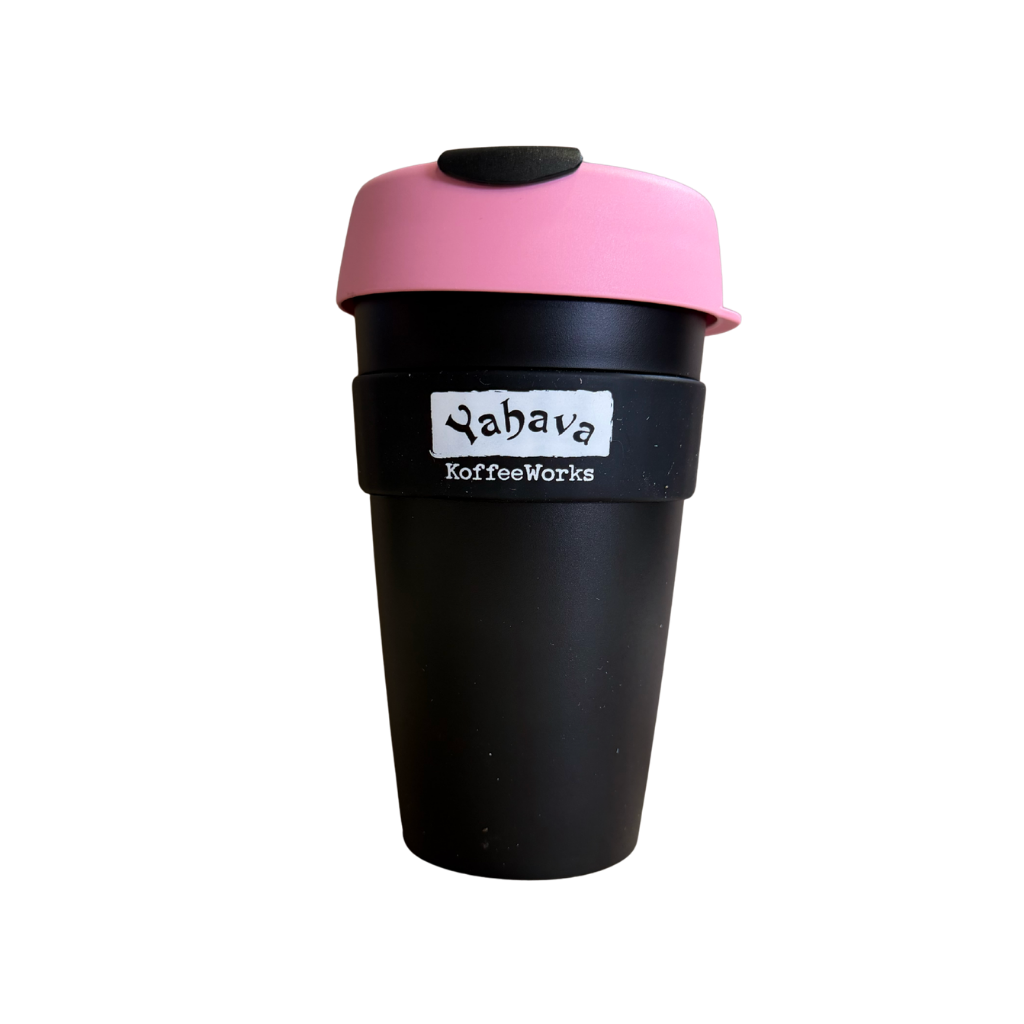 A reusable coffee cup with a matte black body, a pink lid, and a black silicone grip band featuring the 'Yabava KoffeeWorks' logo.