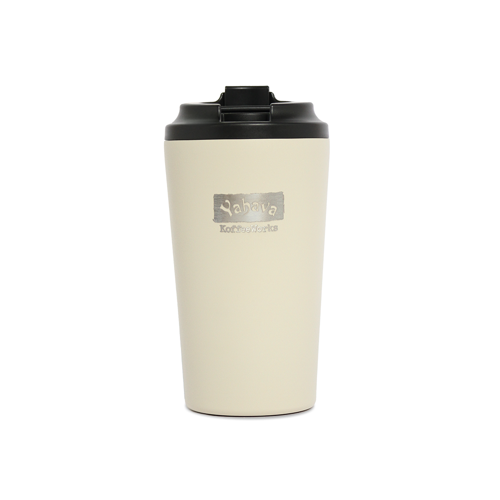 A oat/cream travel mug with a black lid, branded with Yahava KoffeeWorks on the front.