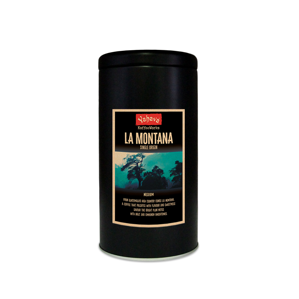 A black 500g tin with Yahava Signature Range coffee label for La Montana on the tin featuring a blue and black rainforest mountain side. 